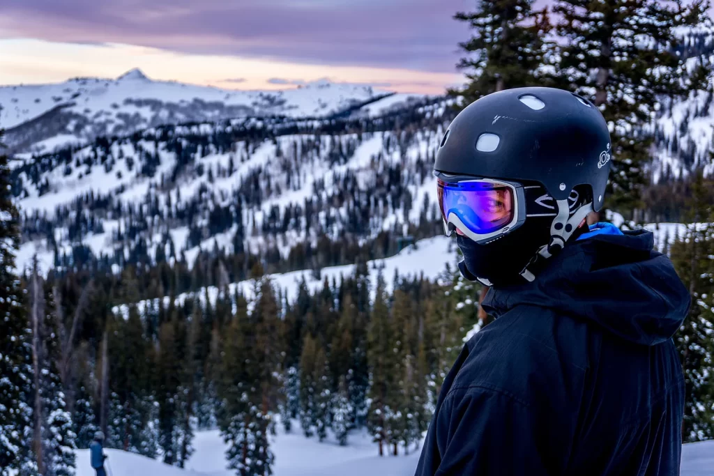 Skieur casqué portant un masque de ski à écran miroir face aux montagnes enneigées de l'Utah