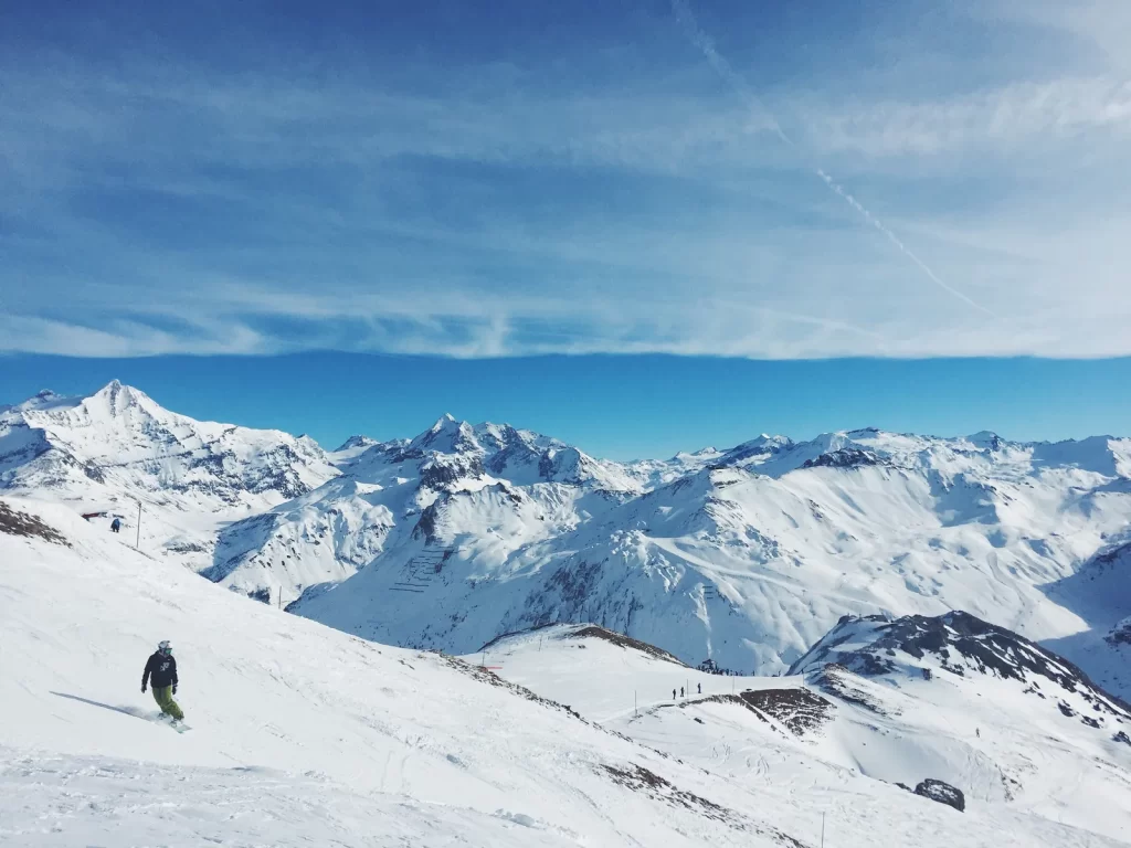 Snowboardeur sur une crête enneigée au-dessus des nuages à Tignes